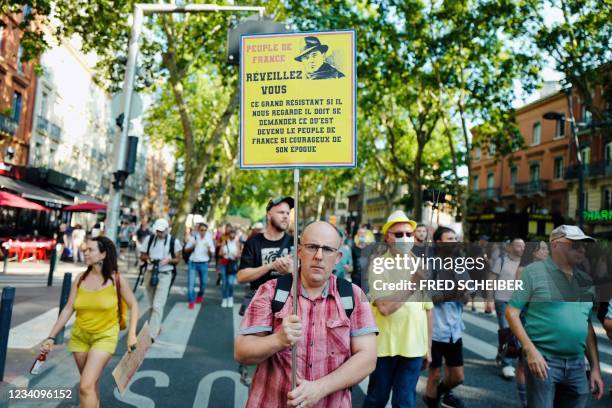 Protester holds a banner depicting World War II French resistant Jean Moulin as he demonstrates against the health pass, in Toulouse, south western...