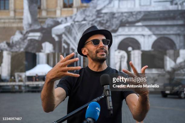 French contemporary artist JR speaks to the media in front of his art installation "Punto di Fuga" on the facade of Palazzo Farnese, on July 21, 2021...