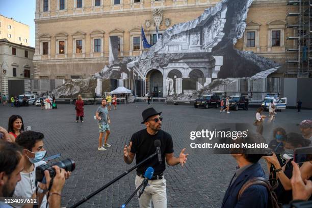 French contemporary artist JR speaks to the media in front of his art installation "Punto di Fuga" on the facade of Palazzo Farnese, on July 21, 2021...