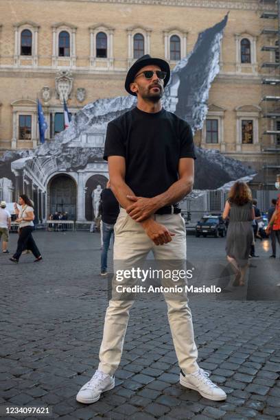 French contemporary artist JR poses in front of his art installation "Punto di Fuga" on the facade of Palazzo Farnese, on July 21, 2021 in Rome,...