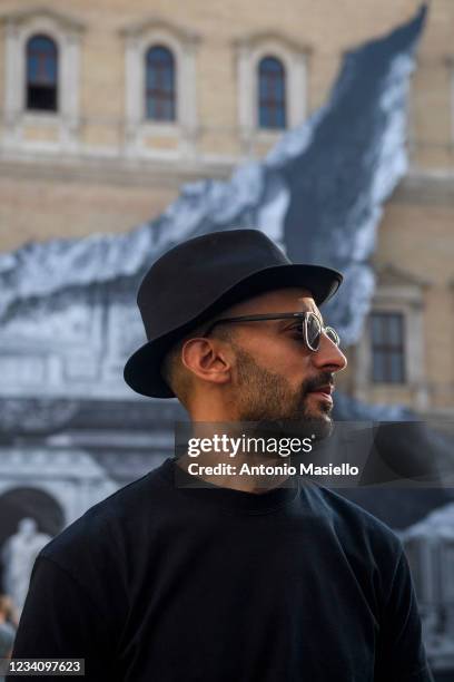 French contemporary artist JR speaks to the media in front of his art installation "Punto di Fuga" on the facade of Palazzo Farnese, on July 21, 2021...