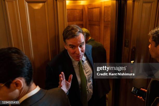 Sen. Mark Warner speaks with reporters outside the Senate Chamber on Capitol Hill on Wednesday, July 21, 2021.