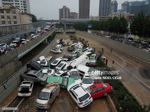 An aerial view shows cars sitting in floodwaters at the entrance of a tunnel after heavy rains hit the city of Zhengzhou in China's central Henan...