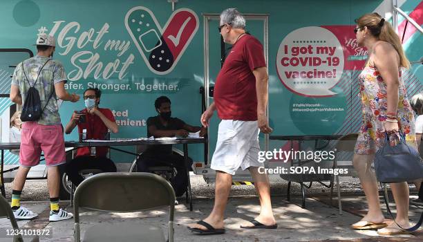 People arrive for shots at a mobile COVID-19 vaccination site. New COVID-19 cases in Florida have doubled in the past week, with most cases...