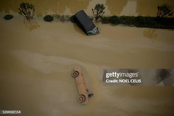 Cars sit in floodwaters following heavy rains, in Zhengzhou in China's central Henan province on July 22, 2021.