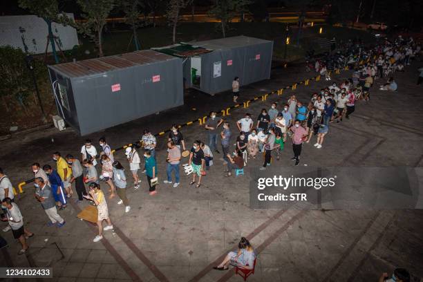 This photo taken on July 21, 2021 shows residents queueing to receive a nucleic acid test for the Covid-19 coronavirus in Nanjing, in eastern Jiangsu...