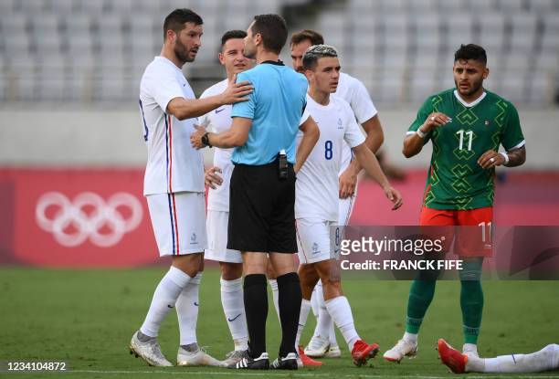 France's forward Andre-Pierre Gignac talks to Australian referee Chris Beath during the Tokyo 2020 Olympic Games men's group A first round football...