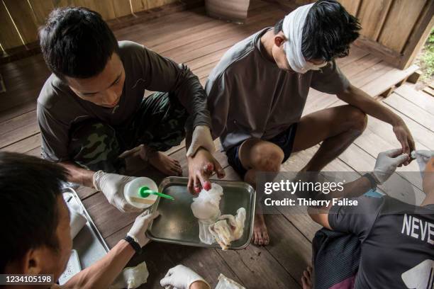 Medics from the Free Burma Rangers change the dressing of Mee They, a young man victim of a anti-personnel mine. The FBR is a relief group created in...