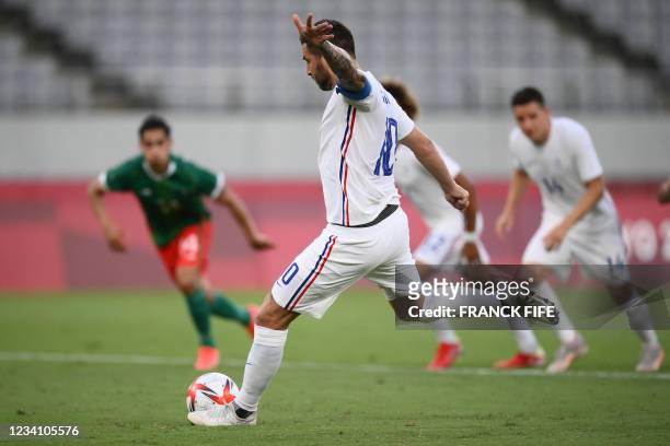 France's forward Andre-Pierre Gignac shoots a penalty kick and scores France's first goal during the Tokyo 2020 Olympic Games men's group A first...