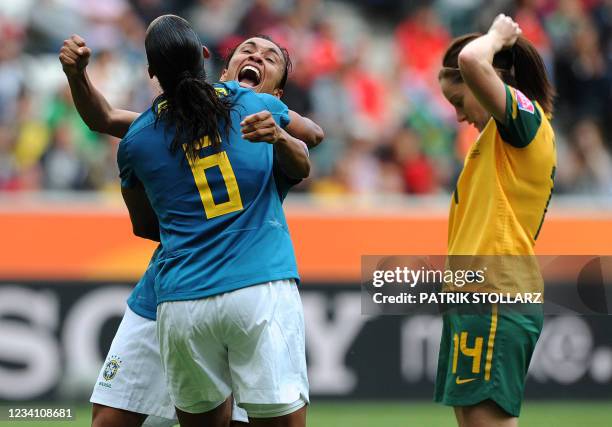Brazil's striker Marta and defender Rosana celebrate after the 1-0 goal by Rosana vies with Australia's midfielder Collette McCallum during the group...