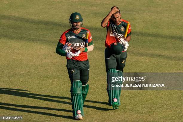 Bangladesh's batsman Nurul Hasan and teammate Mohammad Naim walk back to the pavilion after victory in the first Twenty20 international cricket match...