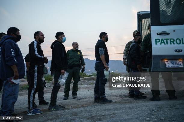 Migrants caught crossing the US-Mexico border are loaded into a transport van by US Border Patrol agents in Sunland Park, New Mexico on July 22,...