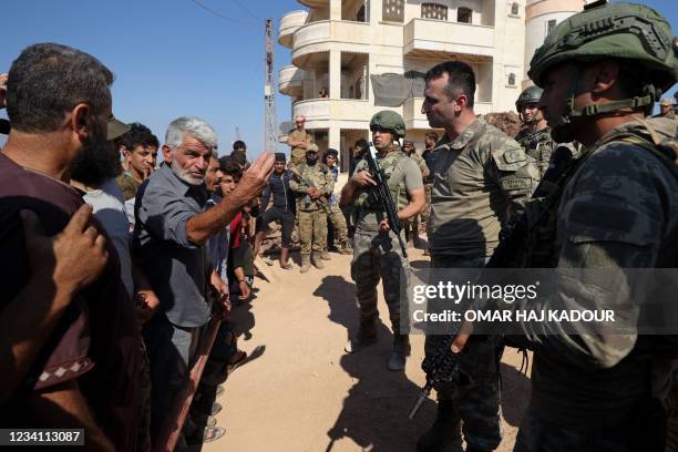 Syrian protesters confront Turkish soldiers during a demonstration against Turkey's perceived inaction over the latest Syrian regime attacks, in the...