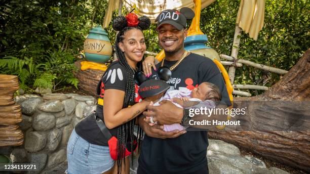 In this handout photo provided by Disneyland Resorts, Ne-Yo, Crystal Renay and their daughter Isabella Rose visit Disneyland Park on July 22 in...