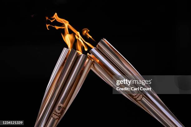 Flames are exchanged during the arrival ceremony for the Olympic torch on July 23, 2021 in Tokyo, Japan.
