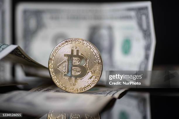 Bitcoin golden physical coin illustration on United States Dollar banknotes. Visual representations of the digital Cryptocurrency Bitcoin with the...