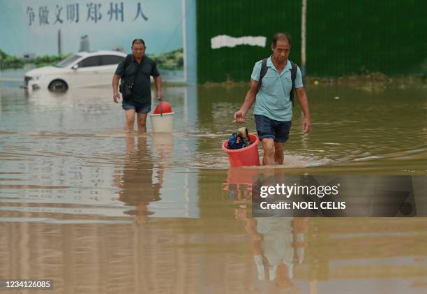 People cross a flooded street following heavy rain that flooded and claimed the lives of at least 33 people earlier in the week, in the city of...