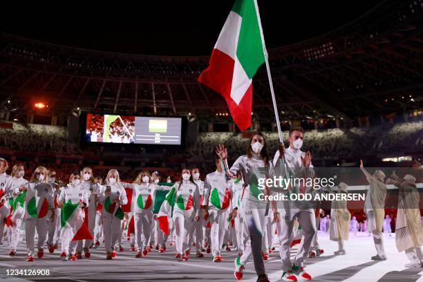 Italy's flag bearers Elia Viviani and Italy's Jessica Rossi lead their delegation as they parade during the opening ceremony of the Tokyo 2020...
