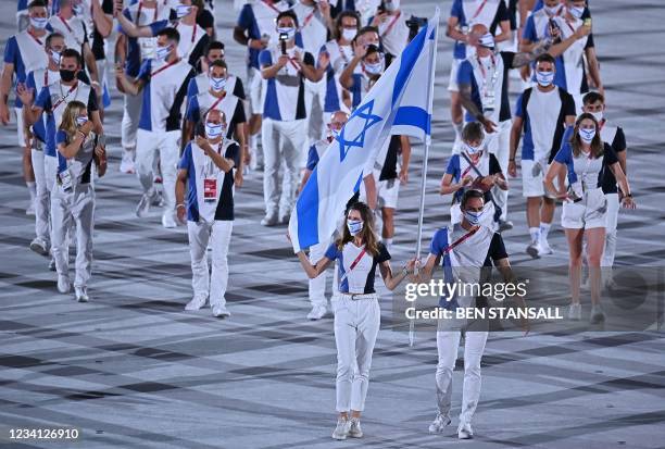 Israel's flag bearer Hanna Minenko and Israel's flag bearer Yakov Toumarkin lead the delegation during the opening ceremony of the Tokyo 2020 Olympic...