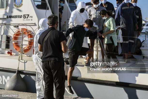 Rescued refugees and migrants disembark from greek coast guard vessel at the port of Ierapetra, on Island of Crete on July 23, 2021. - A dozen...