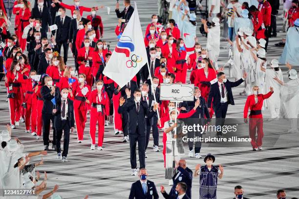 July 2021, Japan, Tokio: Olympics: Opening Ceremony at the Olympic Stadium. The Russian Olympic Committee team with flag bearers fencer Sofya...