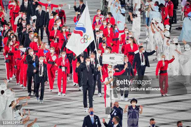 July 2021, Japan, Tokio: Olympics: Opening Ceremony at the Olympic Stadium. The Russian Olympic Committee team with flag bearers fencer Sofya...