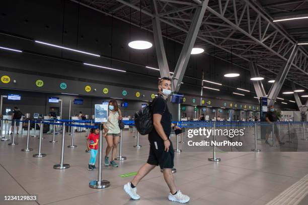 People in the departure hall with the check in desks at Thessaloniki International Airport Makedonia SKG LGTS in Northern Greece. Passengers with...