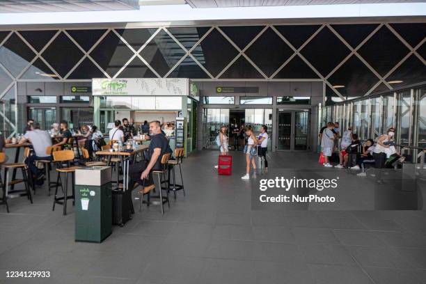 People enjoy a beverage before their flight out of the departure hall of the new T2 with the check in desks at Thessaloniki International Airport...