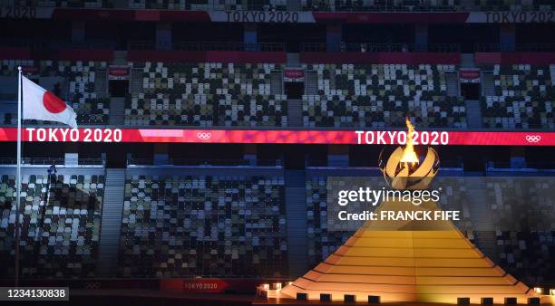 Empty seats are seen as the Olympic Flame burns after the lighting of the Olympic Cauldron during the opening ceremony of the Tokyo 2020 Olympic...