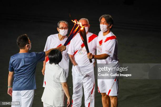 Shigeo Nagashima, Hideki Matsui and Sadaharu Oh pick up the Olympic flame during the Tokyo 2020 Olympic Games Opening Ceremony at Olympic Stadium on...