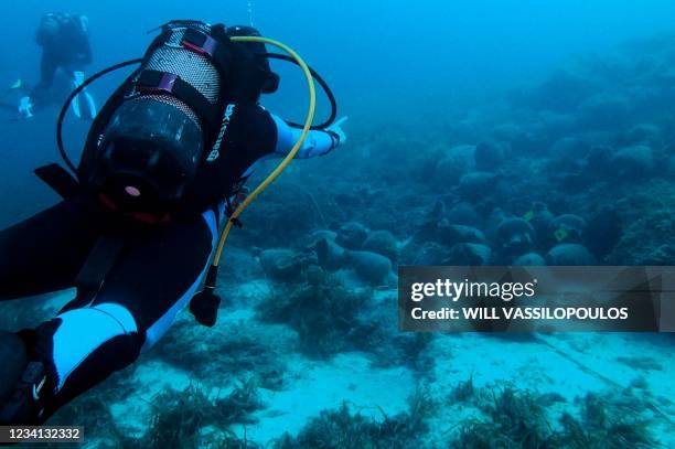 Scuba divers visit the underwater museum in the Aegean Sea, off the coast of the Greek island Alonissos on July 20, 2021. - Resting at a near 30...