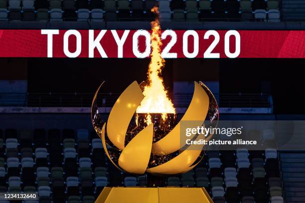 July 2021, Japan, Tokio: Olympia: Opening ceremony in the Olympic Stadium. The Olympic fire is burning. Photo: Swen Pförtner/dpa