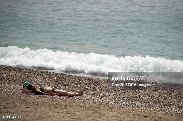 Woman is seen sunbathing at Malagueta beach during a hot summer day amid coronavirus pandemic. The state weather agency AEMET said that the next days...