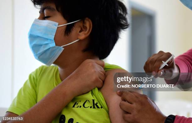 Minor receives a dose of the Pfizer-BioNTech vaccine against COVID-19 at a vaccination center in Asuncion, on July 23, 2021. Paraguay started to...