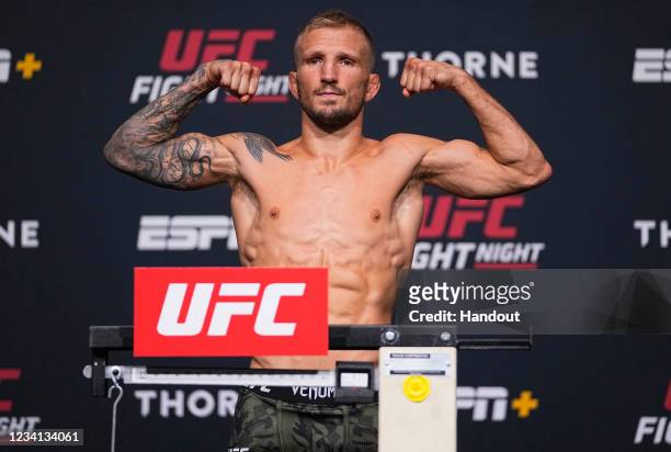 In this handout photo provided by UFC, T.J. Dillashaw poses on the scale during the UFC Fight Night weigh-in at UFC APEX on July 23, 2021 in Las...