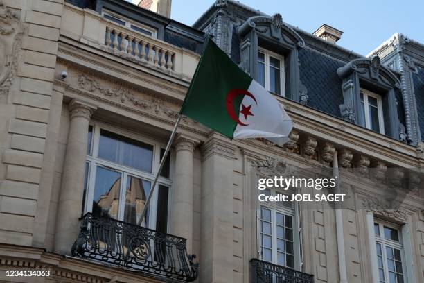 Picture taken on July 23, 2021 shows an Algerian flag fluttering on the facade of the embassy in Paris. - Algeria expressed "deep concern" following...