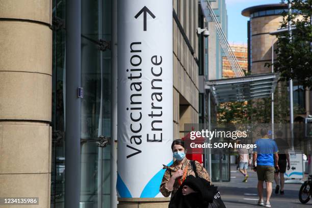 Woman walks past a vaccination centre.