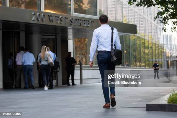 An office worker walks toward the Goldman Sachs Group Inc. Headquarters in New York, U.S., on Thursday, July 22, 2021. After a year of Zoom meetings...
