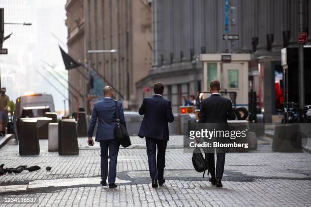 Pedestrians walk along Wall Street near the New York Stock Exchange in New York, U.S., on Thursday, July 22, 2021. After a year of Zoom meetings and...