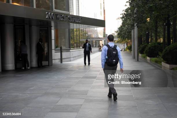 An office worker walks toward the Goldman Sachs Group Inc. Headquarters in New York, U.S., on Thursday, July 22, 2021. After a year of Zoom meetings...