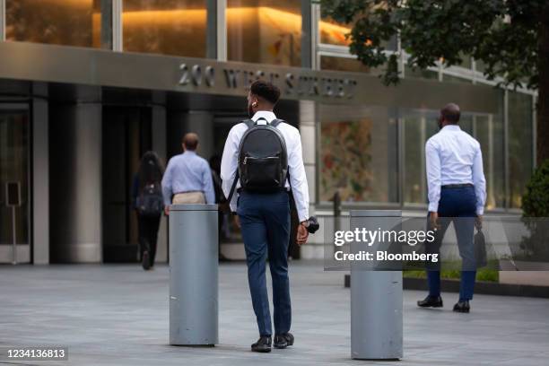 Office workers walk towards the Goldman Sachs Group Inc. Headquarters in New York, U.S., on Thursday, July 22, 2021. After a year of Zoom meetings...
