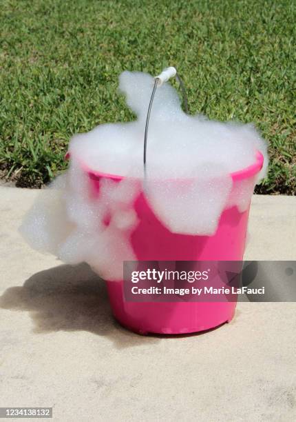 plastic bucket with overflowing soap bubbles outdoors - bucket stock pictures, royalty-free photos & images