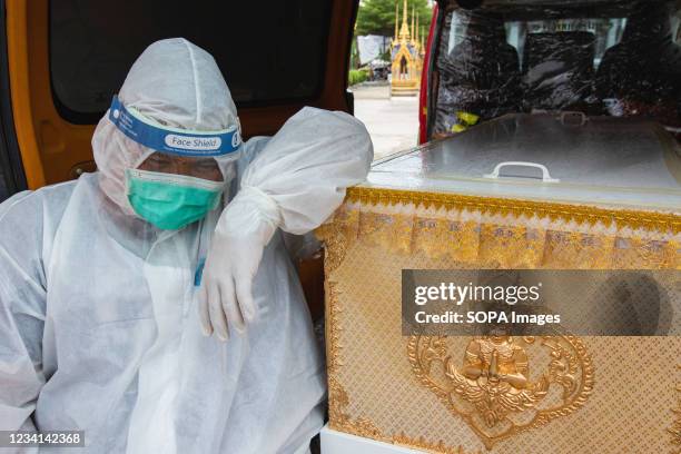 Siam Nonthaburi foundation staff member sits near a coffin of a COVID-19 victim at Sao Thong Hin Temple. As the death toll from COVID-19 in Thailand...