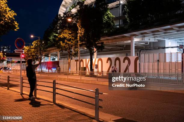 Man takes a picture of the National Stadium on the night before the opening ceremony of the Olympic Games in Tokyo, Japan on 22 July, 2021.