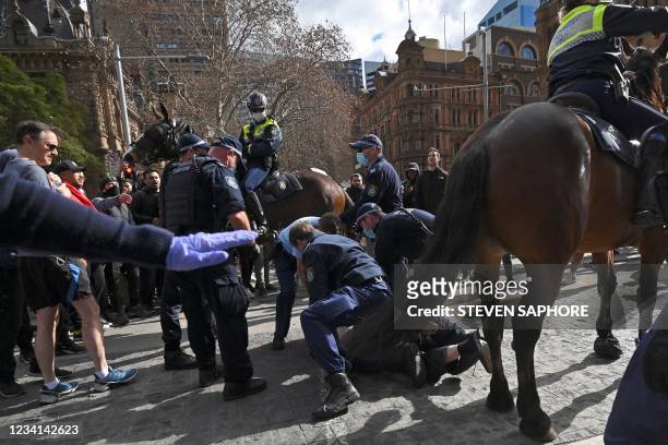 Police officers arrest protesters during a rally in Sydney on July 24 as thousands of people gathered to demonstrate against the city's month-long...