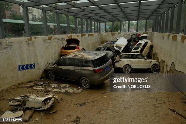 Damaged vehicles stacked on each other are seen in a car park following heavy rain which caused flooding earlier in the week that claimed at least 56...