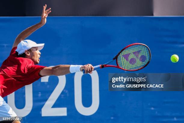 Japan's Ben McLachlan returns a shot to Portugal's Pedro Sousa and Portugal's Joao Sousa during their Tokyo 2020 Olympic Games men's doubles first...