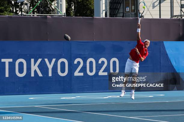 Japan's Kei Nishikori serves to Portugal's Pedro Sousa and Portugal's Joao Sousa during their Tokyo 2020 Olympic Games men's doubles first round...