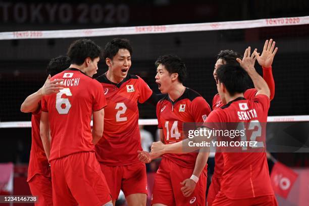 Japan's players react after a point in the men's preliminary round pool A volleyball match between Japan and Venezuela during the Tokyo 2020 Olympic...