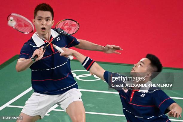 Malaysia's Aaron Chia and Malaysia's Soh Wooi Yik go for a shot in their men's doubles badminton group stage match against South Korea's Choi Sol-gyu...